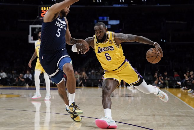 詹姆斯(右)無視對方盯防持球強行切入。(美聯社)
