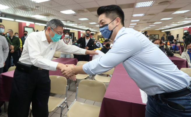  国民党台北市长参选人蒋万安（右）与台北市长柯文哲（左）13日均出席新党台北市议员侯汉廷新书发表会，两人在会前入座时互相握手致意。（郑任南摄）