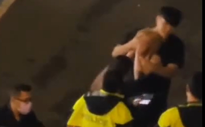 9歲闕姓女子13日凌晨喝得爛醉，突然對著騎機車經過的女子大罵三字經，警方到場後一旁男友人看不下去連忙摀嘴制止。(翻攝自影片)