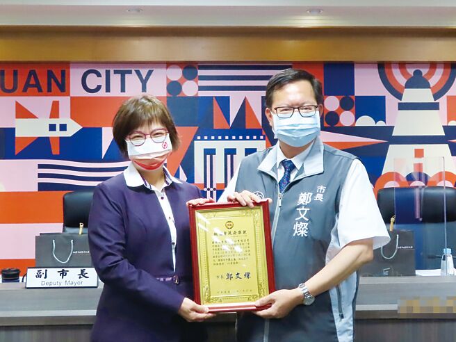 桃园市市长郑文灿（右）颁发奖状，给代表受奖的华银北三区通路管理中心协理黄琬玲。图／华南银行提供