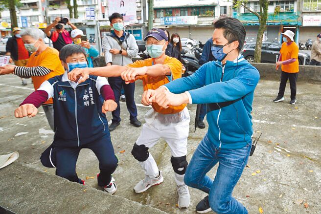 國民黨台北市長參選人蔣萬安（右）12日一早到南港玉成公園向晨運的民眾請託拜票，在民眾的邀約下一同做深蹲。（黃世麒攝）