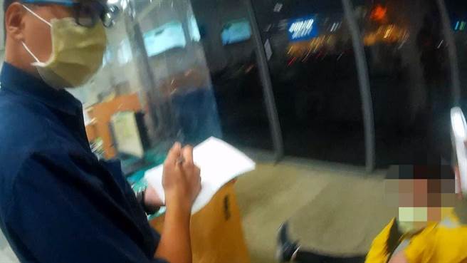 员警协助不支倒地的刘男测量体温。（翻摄照片／林郁平）