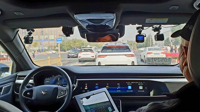 百度研发的第五代无人自动驾驶车，车辆自动执行起步、加减速、转弯、变换车道、避让障碍物等动作，只有副驾驶座上的随车工程师负责监控车辆状态。（蓝孝威摄）