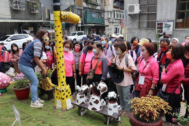 彰化县社区照顾关怀据点的干部在永盛公园新造景前纷纷取镜。(新北市社会局提供)