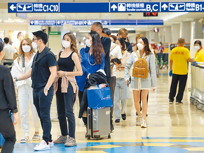 国境管制解封，桃园机场13日入境预报人数有12639人，13日傍晚时段一小时内入境旅客1084人，旅客在入境长廊排队领取快筛试剂。（陈麒全摄）