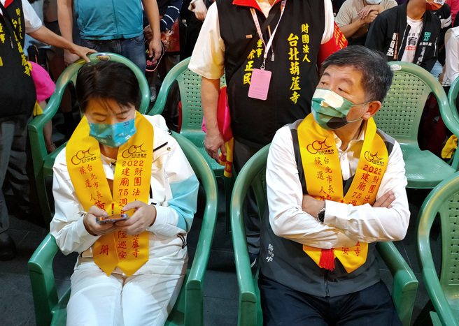 台北葫蘆寺15日舉辦「九聖齊臨 水陸除瘟遶境起駕大典」，邀請台北市長參選人蔣萬安、陳時中（右）以及黃珊珊（左）到場，陳時中與黃珊珊雖然有握手致意，但後來兩人短暫比鄰而坐後就幾乎沒有互動，黃則是努力滑手機，略顯尷尬。（張鎧乙攝）