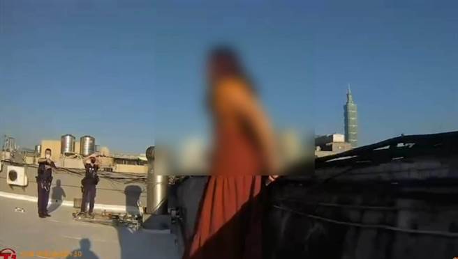 红衣妇人站在顶楼墙边险象环生，在员警耐心劝说下才解除危机。（翻摄照片／林郁平）