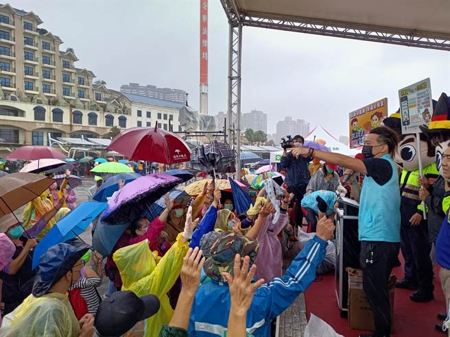 国际狮子会15日在淡水渔人码头举办「反毒、反飙车、反贿选、反诈骗」健行活动，虽然天公不做美，但仍有近千位民眾不畏风雨，穿雨衣或撑伞热情参与。(淡水警分局提供)