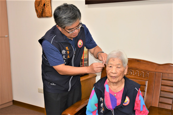 嘉邑行善团徐文志理事长亲自为阿嬷戴上助听器，希望能帮她改善生活。（图／翻摄自FB嘉义市嘉邑行善团官网）