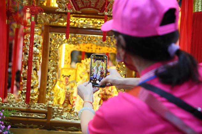 台北市士林区社子葫芦寺适逢建庙75周年，有感新冠肺炎疫情肆虐、民心彷徨，为弘扬观音佛祖的眾神慈悲救苦精神，15日起举办「「葫芦寺九圣除瘟赐福大典遶境」活动，一位信徒在起驾前拍摄观音佛祖金身。（张铠乙摄）