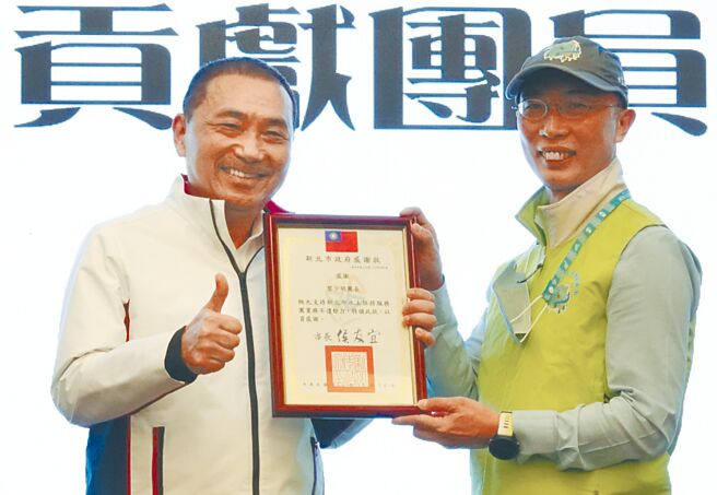 新北市水土保持服务团连续2年获得农委会评核为全国绩优，现任团长黎少明（右）获新北市长侯友宜（左）表扬。（蔡雯如摄）