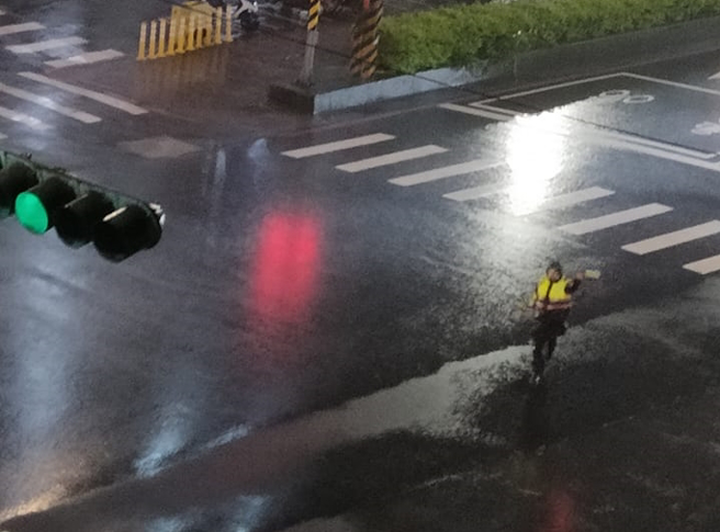 汐止1名民眾昨晚（15）在路口发现1名员警顶着强风骤雨指挥交通，过了4小时后，该民眾见到同一名员警仍持续指挥，让他大感心疼。（翻摄自脸书「汐止集团」）