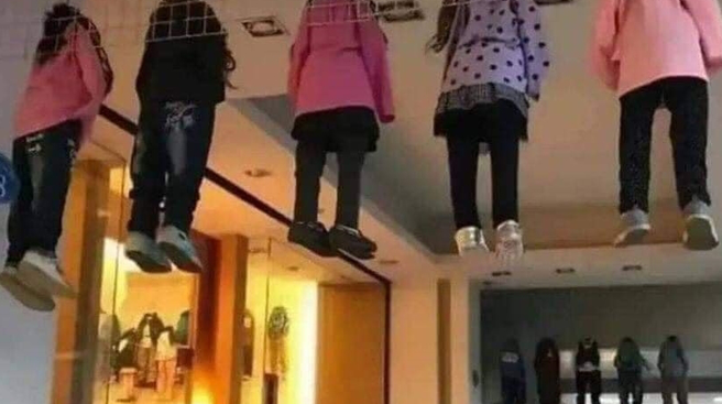 台中1名网友发现一处骑楼上方「挂着5名幼童」，近看原来是童装商店的假人模特儿，该假人搭配好全套衣服，还穿上鞋子，乍看之下就像真人。（翻摄自脸书「爆废公社公开版」）