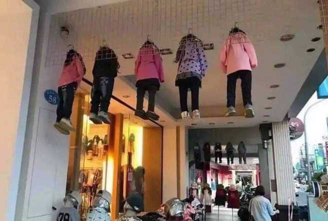 台中1名网友发现一处骑楼上方「挂着5名幼童」，近看原来是童装商店的假人模特儿，该假人搭配好全套衣服，还穿上鞋子，乍看之下就像真人。（翻摄自脸书「爆废公社公开版」）