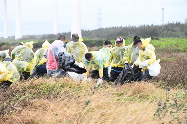 彰化县政府16日在「招潮蟹及水鸟故乡」的伸港溼地举办净滩和海洋环境教育宣导，志工冒着风雨，捡拾800公斤垃圾。（吴敏菁摄）