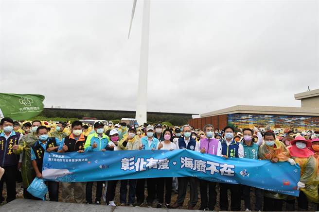 彰化县政府16日在「招潮蟹及水鸟故乡」的伸港溼地举办净滩和海洋环境教育宣导，志工冒着风雨，捡拾800公斤垃圾。（吴敏菁摄）