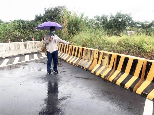 市议员萧隆泽今天冒雨勘查神冈区昌平路5段135巷，抨击经过灌溉沟渠的桥被整排纽泽西护栏挡住去路。(市议员萧隆泽提供)