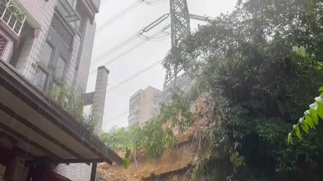 伯爵山庄住宅旁山坡地土石泥流滑落，矗立在山坡上方的1座高压电塔岌岌可危。（翻摄影片）