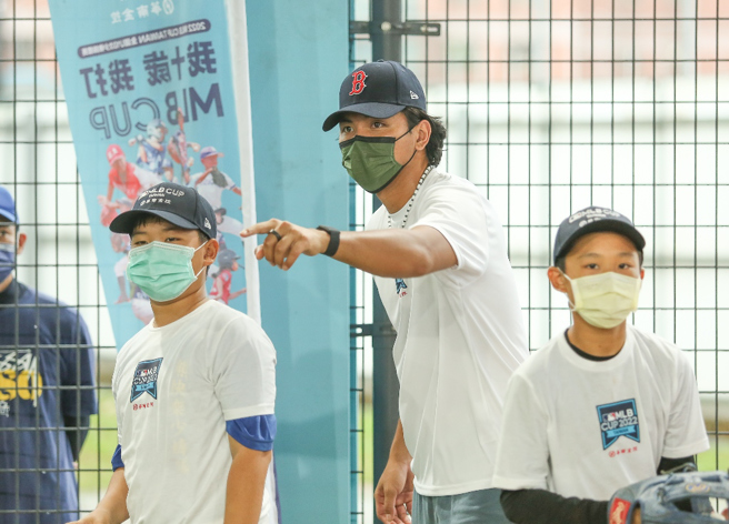 刘致荣（中）在棒球训练营和学员互动。（台湾世界少棒联盟协会提供）