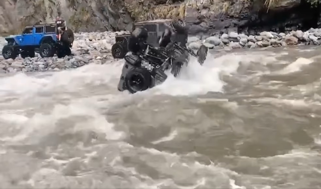 吉普车强行渡溪，惨遭强劲水流猛冲「翻滚一圈」后，卡在岸边石头上。（翻摄自脸书爆废公社公开版）