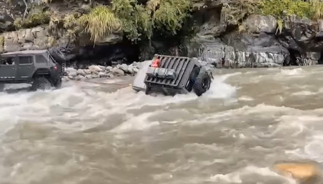 吉普车强行渡溪，惨遭强劲水流猛冲「翻滚一圈」后，卡在岸边石头上。（翻摄自脸书爆废公社公开版）