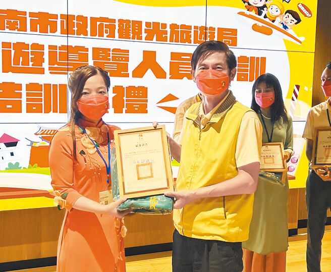 新住民学员完成「新南向旅游导览人员培训」课程后，获台南市政府观光旅游局副局长林国华（右）颁发证书。（洪荣志摄）