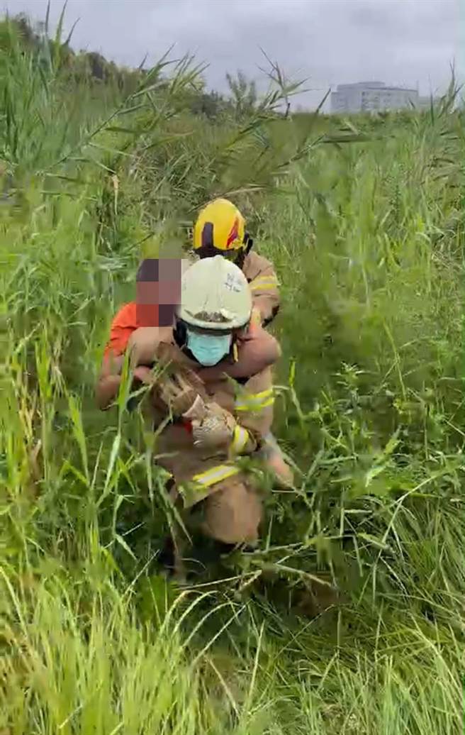 黄男受困草丛2天，遭学生上学途中发现报警，救难人员在草堆中将人扛出。（读者提供／程炳璋台南传真）