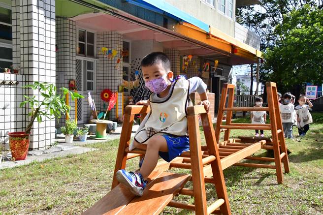 湖西非營利幼兒園及公幼2歲專班的揭牌，縣長王惠美帶著小朋友，走在平衡木上，探索體驗戶外遊戲學習區。（吳敏菁攝）