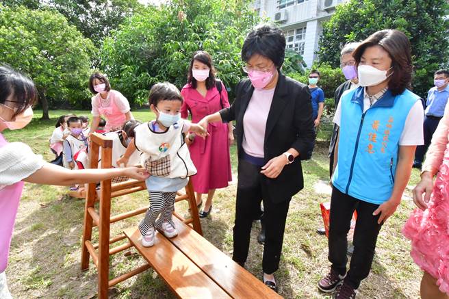 湖西非營利幼兒園及公幼2歲專班的揭牌，縣長王惠美帶著小朋友，走在平衡木上，探索體驗戶外遊戲學習區。（吳敏菁攝）