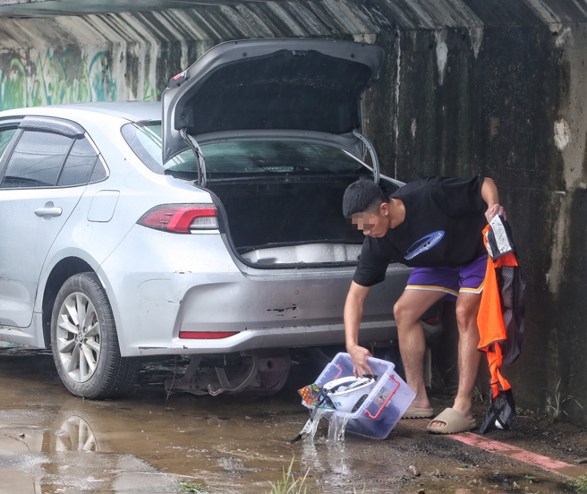 受到尼莎颱风影响，停在百龄桥下停车场的车辆遭水淹没，民眾到场检视爱车泡水状况及清理车内物品。（陈怡诚摄）