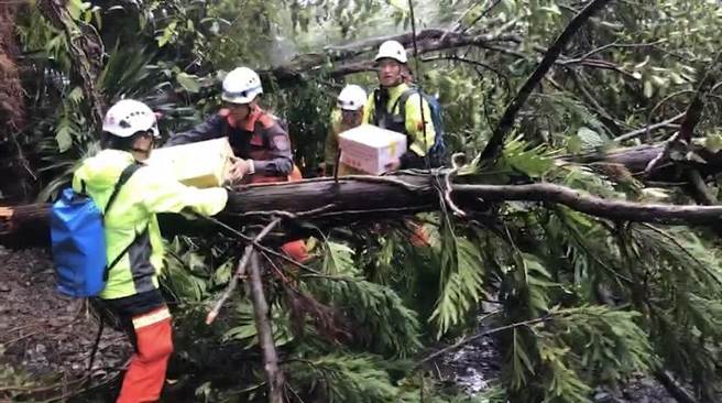 宜兰县长林姿妙今（18日）指示消防局派遣25位救灾人员，徒步行走惊险的坍崩路段，将物资以背负方式运送至山庄。（宜兰县消防局提供／吴佩蓉宜兰传真）