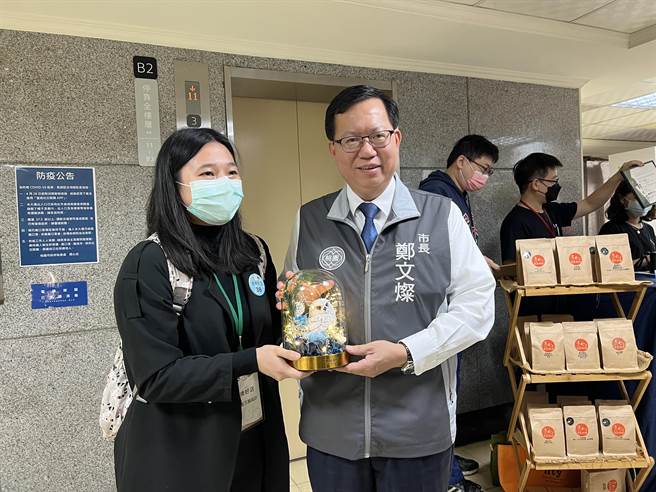 有业者递上手作花艺，里头有象徵智慧的猫头鹰饰品，感谢郑8年来把桃园领导的这么好。(蔡依珍摄)