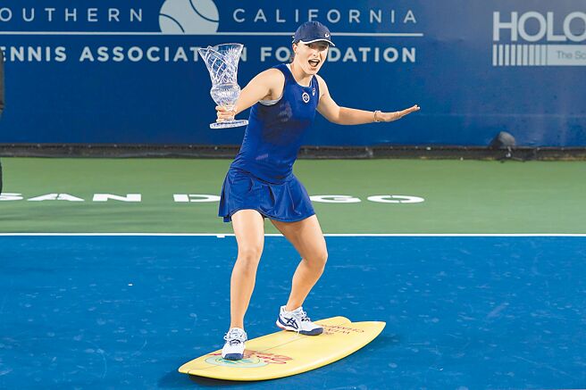 思薇雅蒂站在衝浪板上舉著聖地牙哥女網賽冠軍獎盃慶祝。（美聯社）