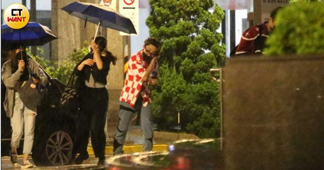 小孩先冒雨快步进入公司，工作人员撑伞继续接其他团员下车。（图／本刊摄影组）