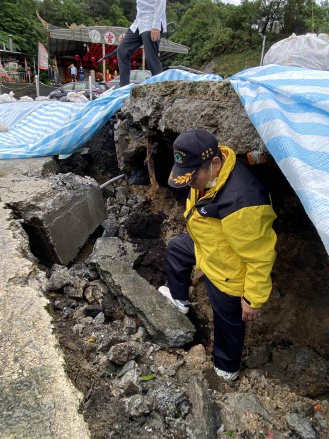 基隆市七堵区东新街北极宫前疑似走山，地层下陷近2公尺，市府铺设防水帆布预防现场塌陷扩大。（张志康摄）
