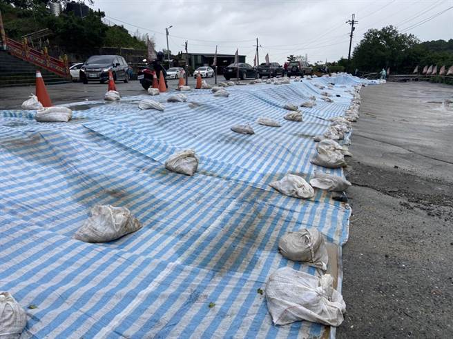 基隆市七堵区东新街北极宫前疑似走山，地层下陷近2公尺，市府铺设防水帆布预防现场塌陷扩大。（张志康摄）