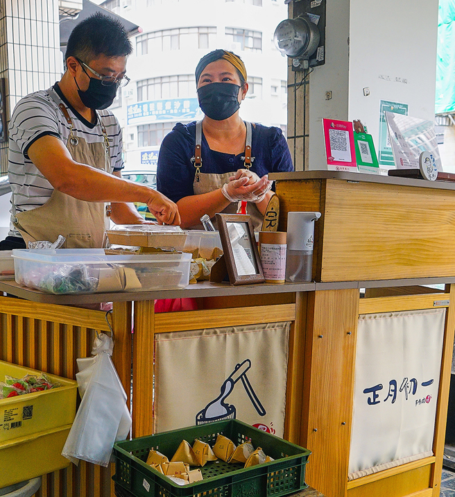 清新和风木作小摊车后方，蓝淯柔正熟练地捏出一颗颗圆滚饱满的麻糬，再由先生接手，包装成可爱的三角饭糰形状，两人合作无间。(摄影/Cindy Lee)
