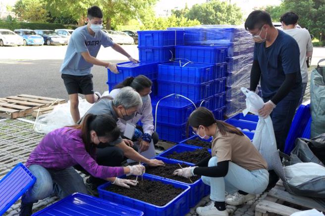 醒吾科大师生将香槟茸基质搬入室内培植工场，菇类专家吴宽泽博士检视现场状况。(醒吾科大提供)