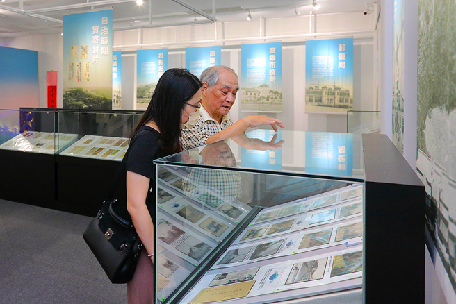 集邮家顏博政走在展区，指着每个收藏品、边说着故事，他希望藉由这些邮品，让更多人认识早期高雄发展史。(摄影/Carter)