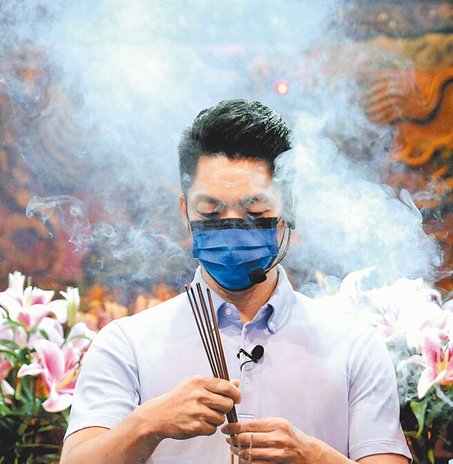 国民党台北市长候选人蒋万安18日在庙宇参拜时，被香火烟雾围绕。（黄世麒摄）