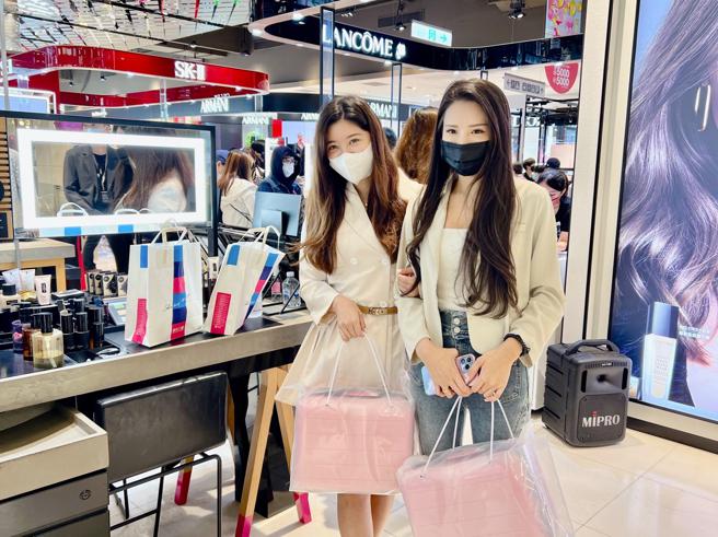 新光三越信义新天地周年庆今（20日）登场，上班族游小姐（左）与友人排头香抢购LANCOME兰蔻登机行李箱赠品。（吴奕萱摄）