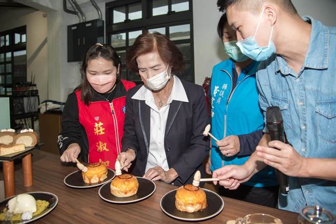 「爆浆玻璃麵包」则是圆蓬麵包淋上薄脆焦糖外衣，搭配一把小木槌，宜兰县长林姿妙（左2）体验敲打破冰的乐趣。（宜兰县政府提供／吴佩蓉宜兰传真）