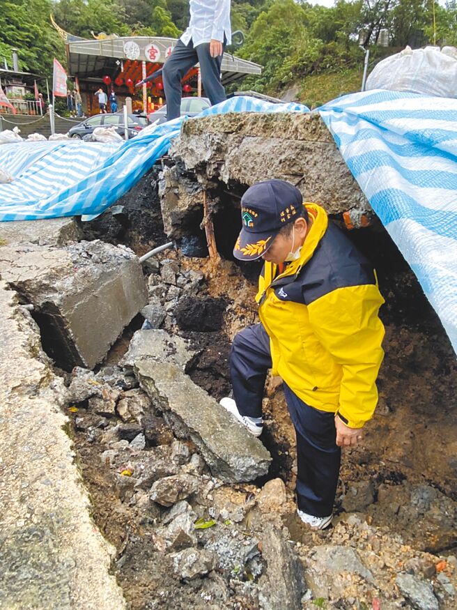 基隆市七堵區東新街北極宮前疑似發生走山，地層下陷近2公尺，市府鋪設防水帆布預防現場塌陷擴大。（張志康攝）