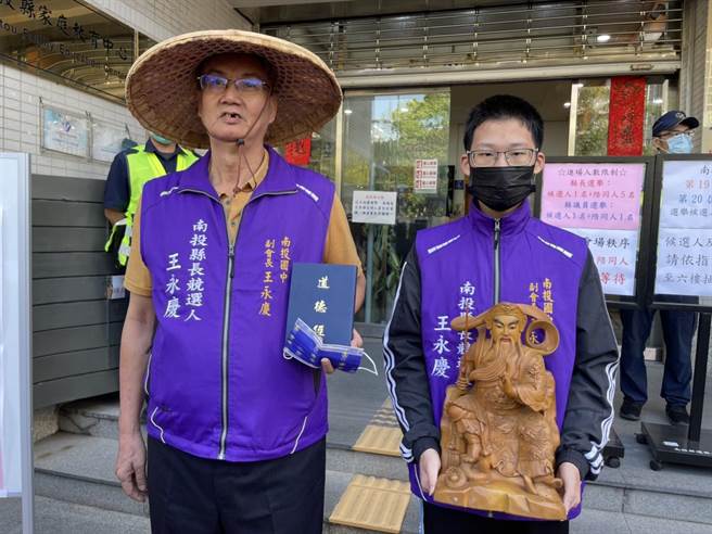 王永慶拿道德經，兒子捧玄天上帝，聲稱帶天兵天將來抽籤。（楊靜茹攝）
