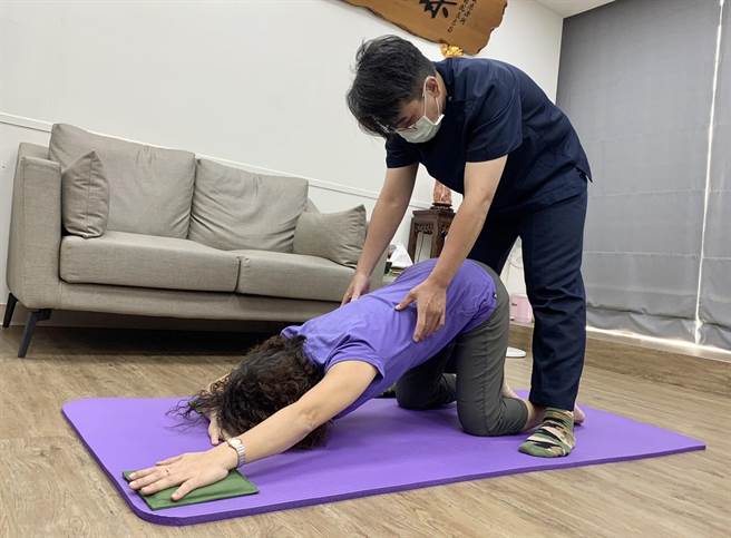 第一式为跪姿延伸，左手延伸，臀部往后移，气吸在左侧胸口。（杨舒婷摄）