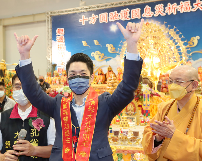 国民党台北市长候选人蒋万安（右）21日出席台湾妈祖联谊会「2022十方圆融消灾祈福大法会」，向现场的法师打招呼，手比自己的选举号数，寻求支持。（郑任南摄）