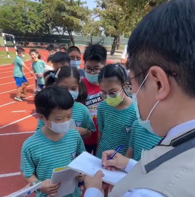 大批小學生圍著黃偉哲要簽名，讓她自嘲，簽愈久就愈寫愈醜，網友笑稱是小朋友罰市長寫名字。(翻攝自黃臉哲)