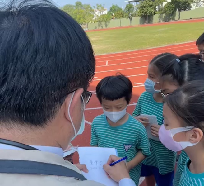 大批小學生圍著黃偉哲要簽名，讓她自嘲，簽愈久就愈寫愈醜，網友笑稱是小朋友罰市長寫名字。(翻攝自黃臉哲)