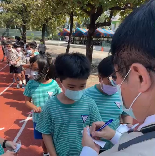 大批小學生圍著黃偉哲要簽名，讓她自嘲，簽愈久就愈寫愈醜，網友笑稱是小朋友罰市長寫名字。(翻攝自黃臉哲)