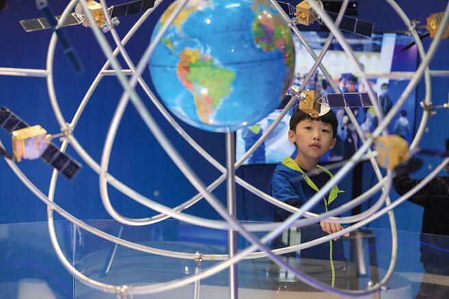 大陆自主研发的北斗卫星导航系统，并列全球四大卫星导航系统之一。图为贵州省一名小朋友在参观「北斗三号全球卫星导航系统」模型。（中新社）